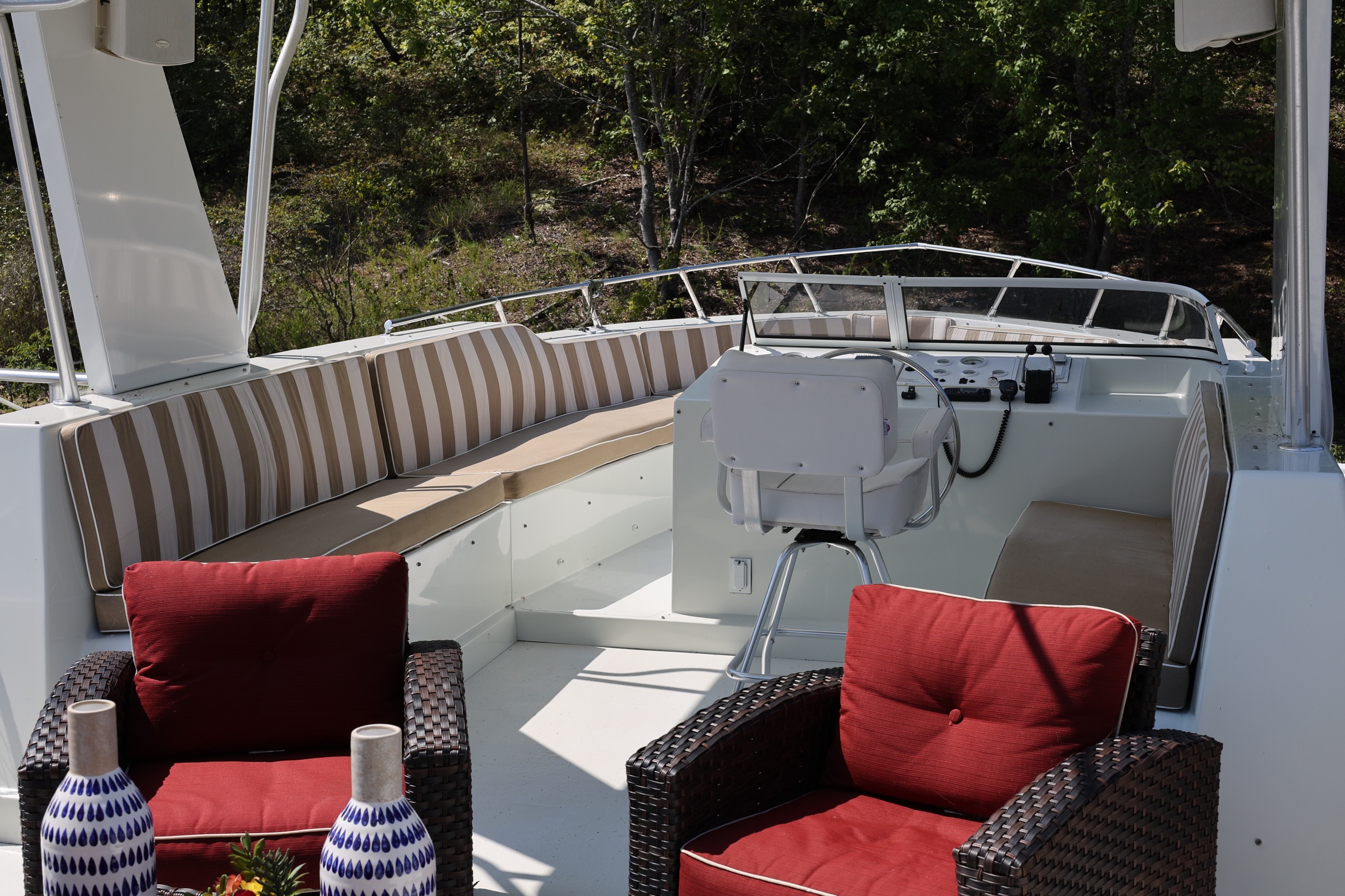 Upper helm and red-cushioned lounge seating on the Sharpe houseboat