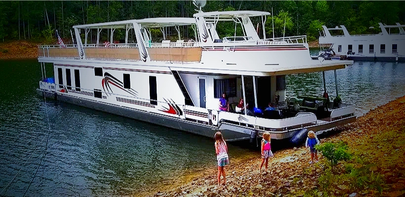 Full exterior of the custom Sharpe houseboat at the shoreline