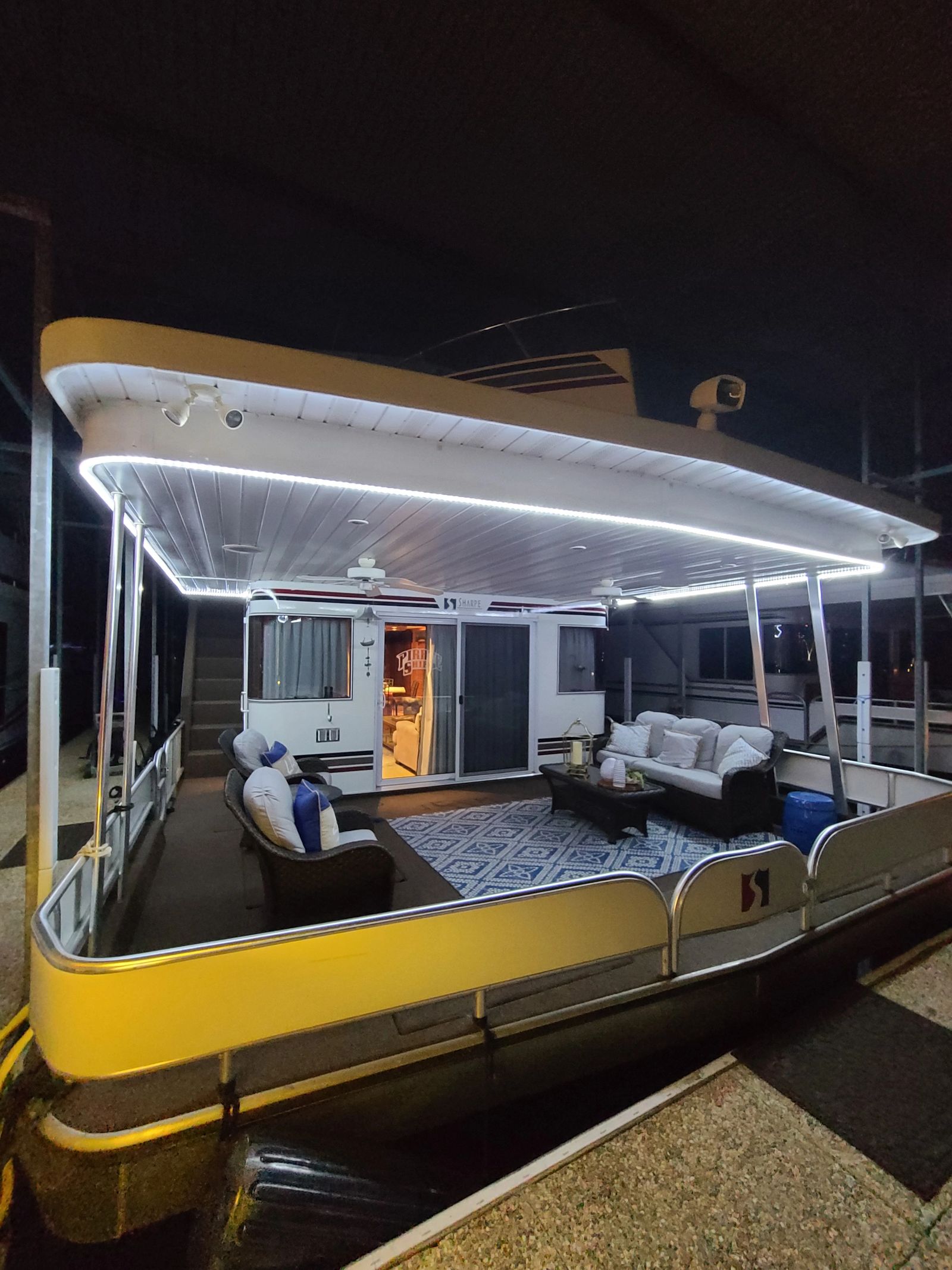 Covered lower-deck lounge with evening lighting