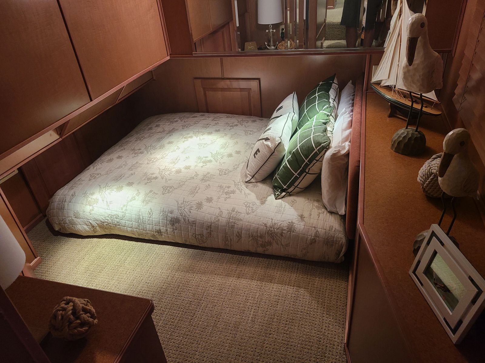 Guest bed framed by warm wood cabinetry