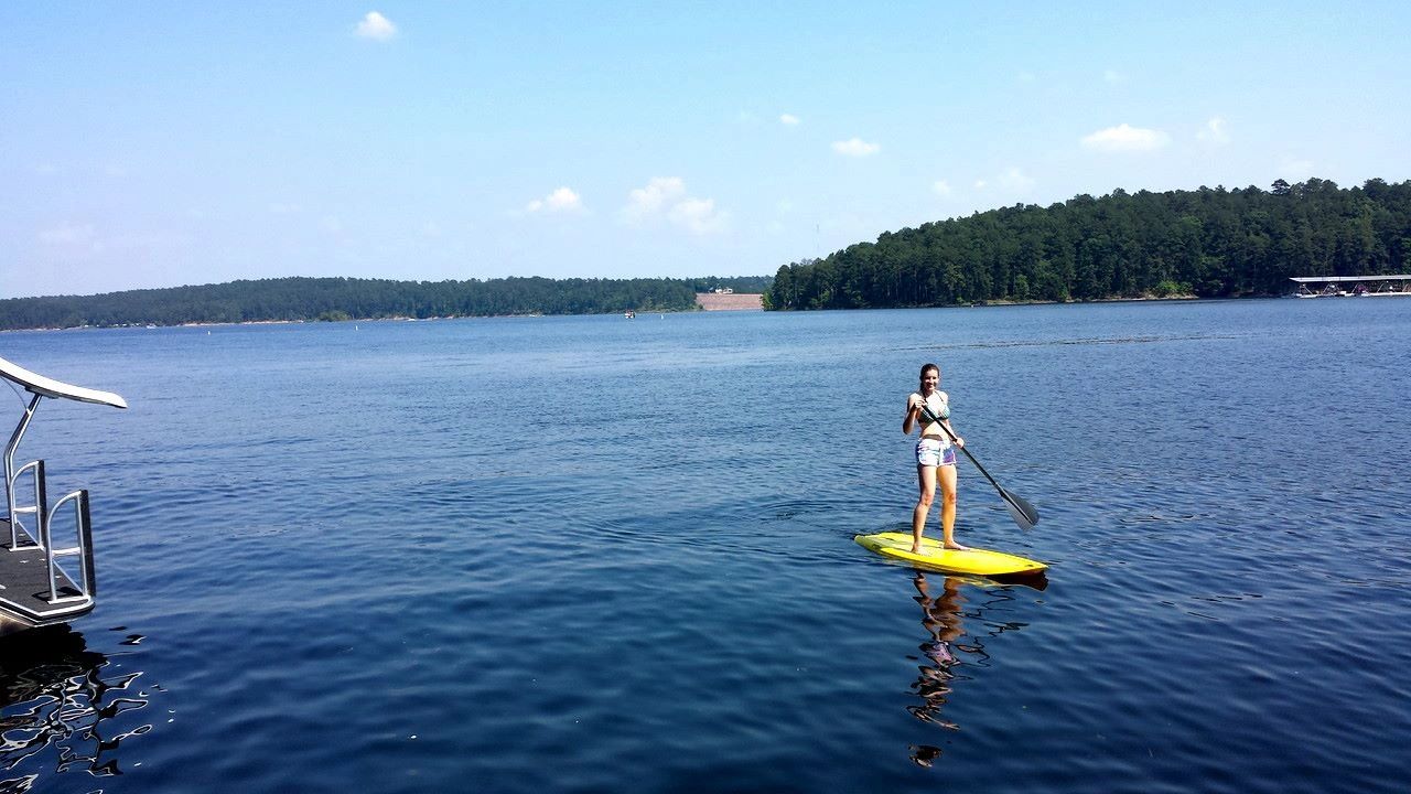 Stand-up paddleboarding on calm Lake DeGray water